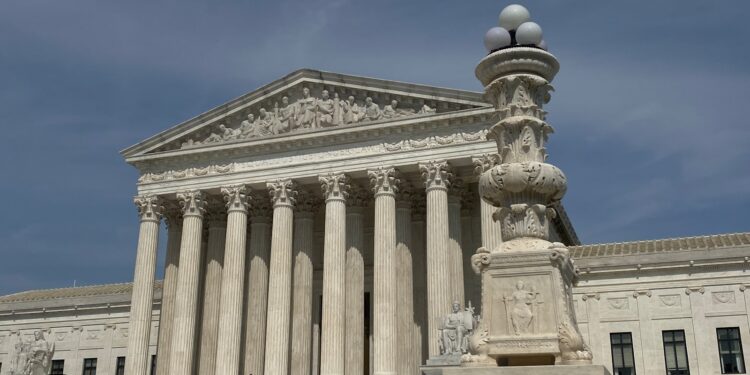 a large building with columns and a clock on top of it